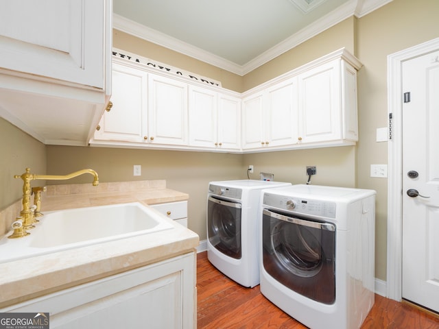 laundry room with hardwood / wood-style floors, sink, cabinets, and ornamental molding