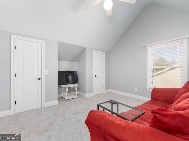 carpeted living room with ceiling fan and vaulted ceiling