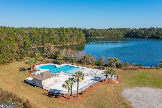 view of pool with a yard and a water view