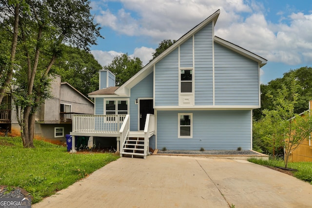 rear view of house featuring a lawn and a wooden deck