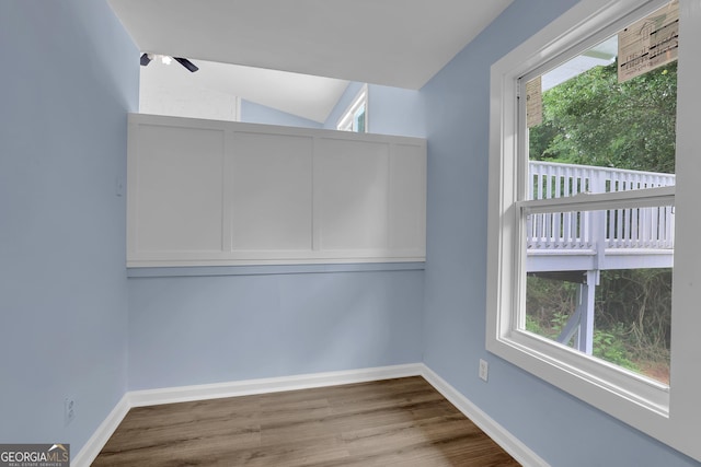 unfurnished room with light hardwood / wood-style floors and vaulted ceiling