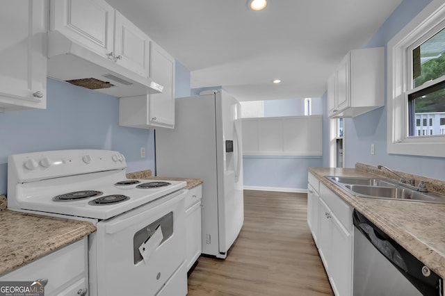 kitchen featuring white cabinetry, sink, white appliances, and light hardwood / wood-style flooring