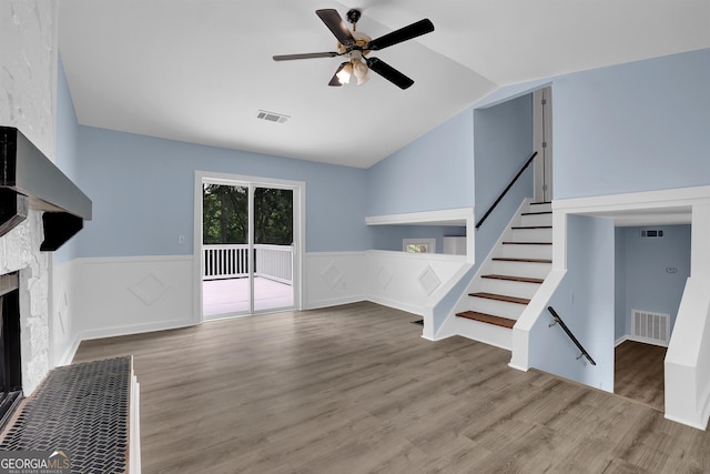 unfurnished living room with ceiling fan, a fireplace, hardwood / wood-style floors, and vaulted ceiling