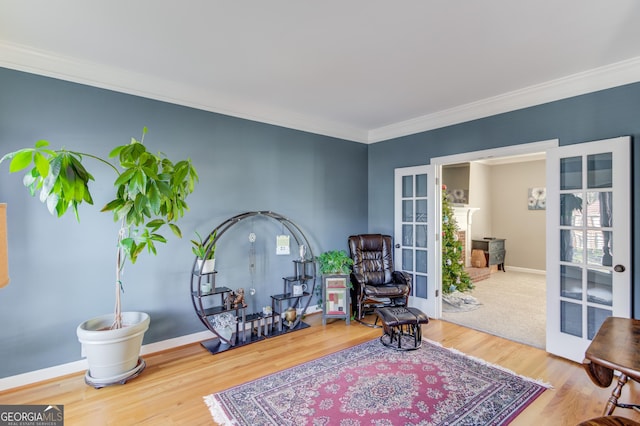 sitting room with hardwood / wood-style flooring, crown molding, and french doors