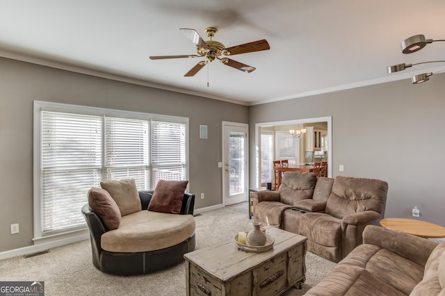 living room with a wealth of natural light, light colored carpet, and ceiling fan with notable chandelier