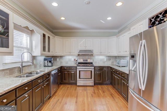 kitchen featuring white cabinets, dark brown cabinetry, sink, and appliances with stainless steel finishes