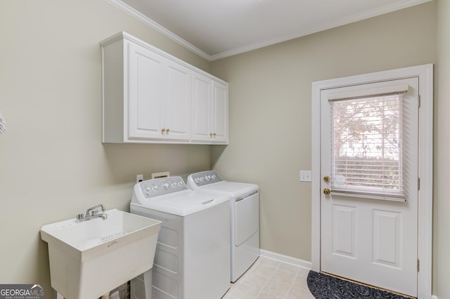 clothes washing area featuring crown molding, cabinets, separate washer and dryer, and sink