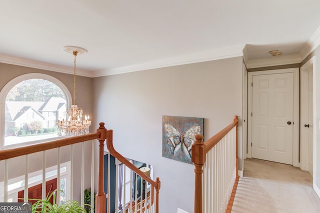 corridor with ornamental molding, light carpet, and a chandelier