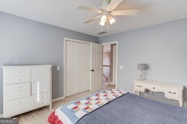 carpeted bedroom featuring ceiling fan and a closet