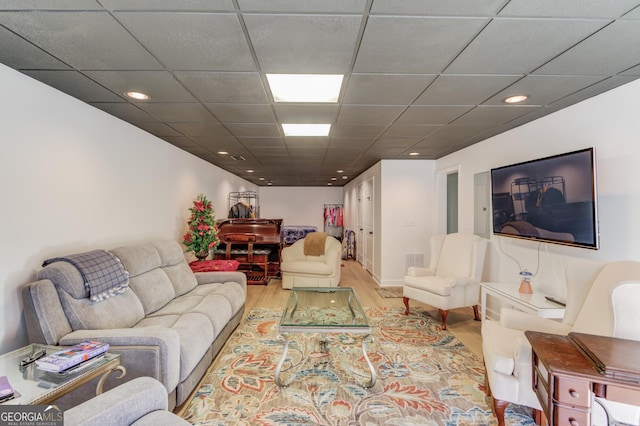 living room featuring a drop ceiling and light hardwood / wood-style floors