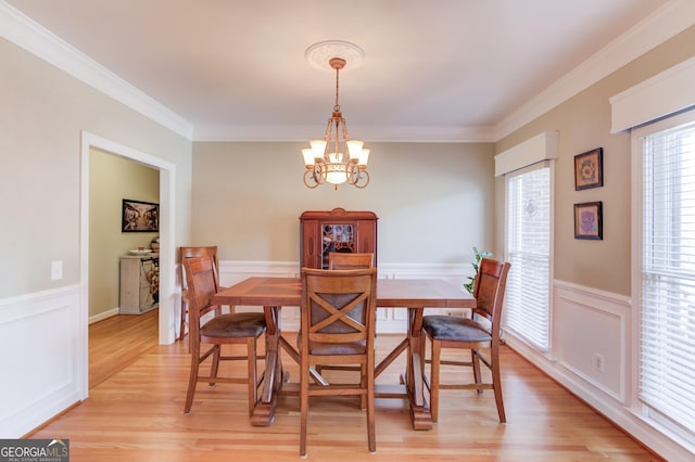 dining room featuring ornamental molding, a chandelier, and light wood-type flooring