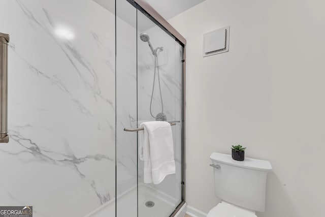 bathroom with a shower with door and toilet