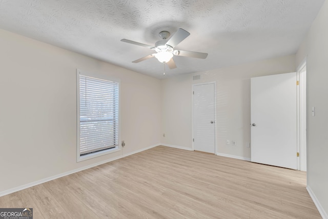 unfurnished room featuring a textured ceiling, light hardwood / wood-style floors, and ceiling fan