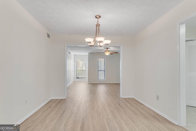 interior space with ceiling fan with notable chandelier, a textured ceiling, and light wood-type flooring