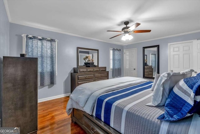 bedroom featuring ceiling fan, ornamental molding, and wood-type flooring