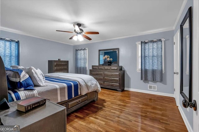 bedroom featuring dark hardwood / wood-style flooring, ceiling fan, and ornamental molding