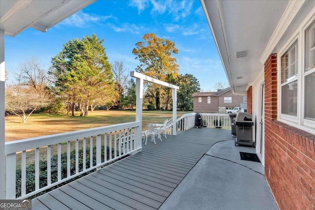 wooden terrace featuring grilling area and a lawn