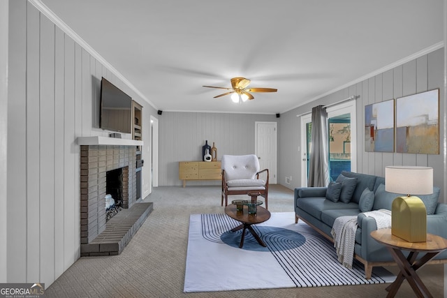 living room featuring light carpet, ornamental molding, ceiling fan, and a fireplace