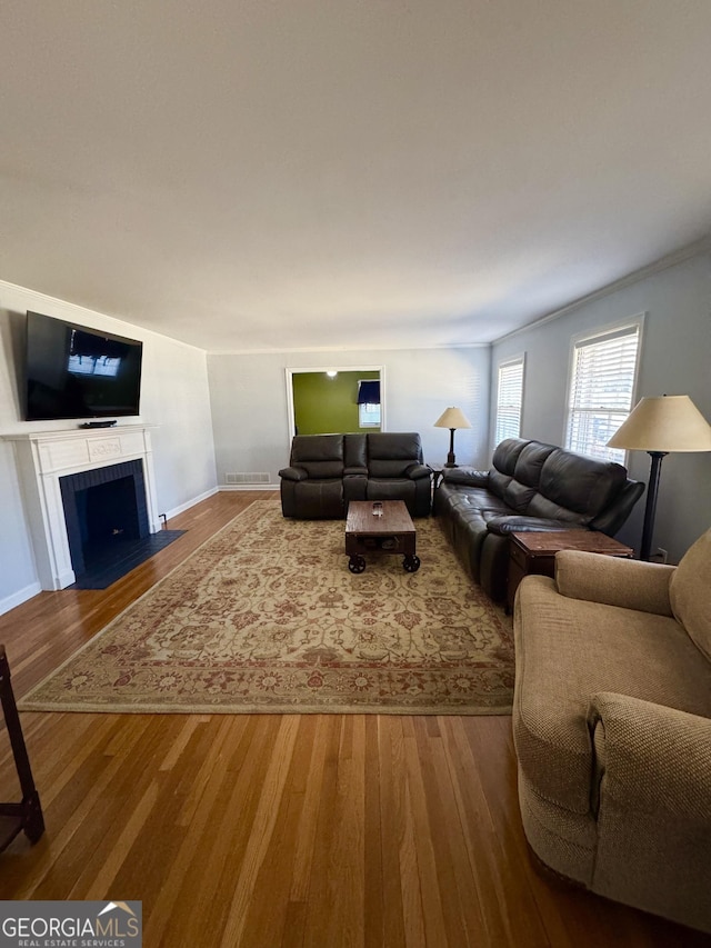 living room with hardwood / wood-style floors and crown molding