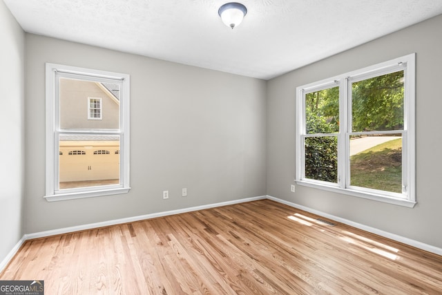 empty room featuring light hardwood / wood-style flooring and a textured ceiling