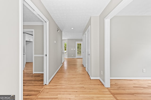 hallway featuring light hardwood / wood-style floors and a textured ceiling