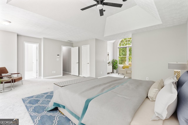 carpeted bedroom featuring ceiling fan and a textured ceiling