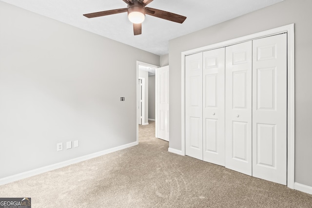 unfurnished bedroom featuring ceiling fan, a closet, and light carpet