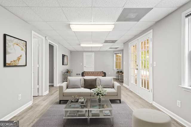 living room with light wood-type flooring and a drop ceiling