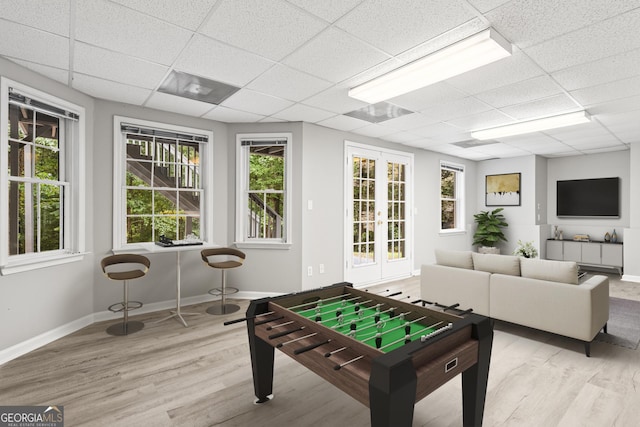 game room with light hardwood / wood-style flooring and a drop ceiling