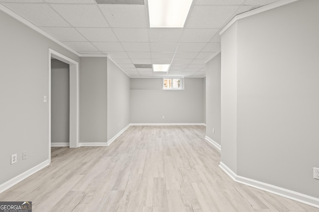 basement featuring a paneled ceiling and light hardwood / wood-style floors