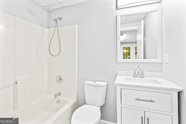 full bathroom with a drop ceiling, vanity, shower / bathtub combination, and toilet