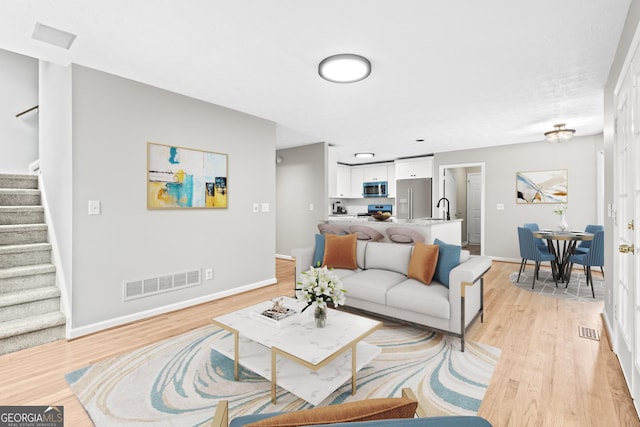 living room featuring light hardwood / wood-style floors and sink