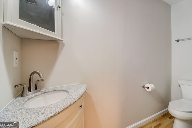 bathroom featuring hardwood / wood-style floors, vanity, and toilet