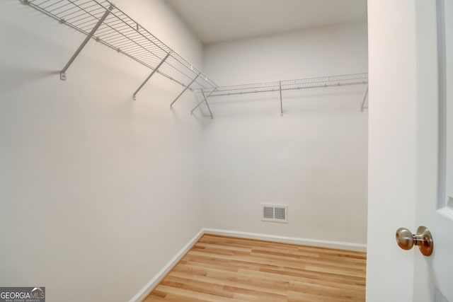 spacious closet with hardwood / wood-style floors