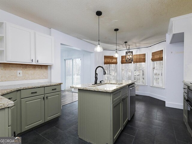 kitchen featuring a kitchen island with sink, plenty of natural light, light stone countertops, and sink