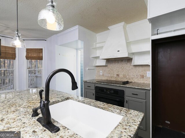 kitchen with hanging light fixtures, premium range hood, gray cabinets, decorative backsplash, and black appliances