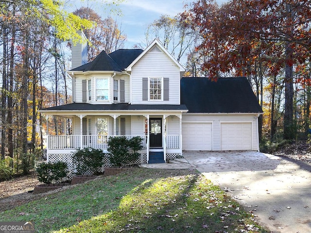 view of front facade with covered porch, a front yard, and a garage