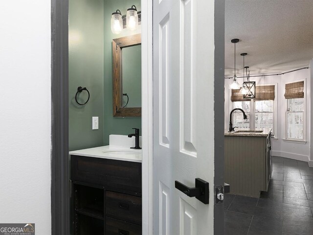 bathroom with a textured ceiling, vanity, and tile patterned floors