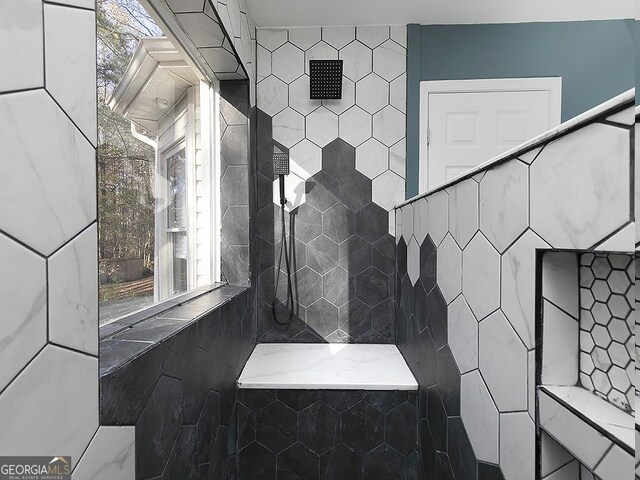 bathroom with tile walls and tiled shower