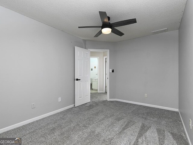 carpeted spare room with a textured ceiling and ceiling fan