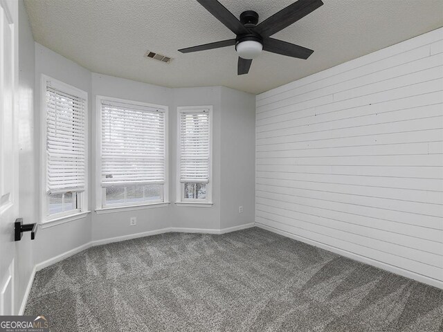 spare room with carpet flooring, a textured ceiling, and ceiling fan