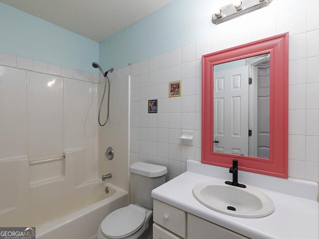 full bathroom featuring shower / bath combination, a textured ceiling, toilet, vanity, and tile walls