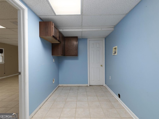 interior space with a drop ceiling and light tile patterned floors