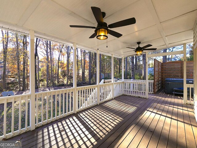 wooden deck featuring ceiling fan and a hot tub