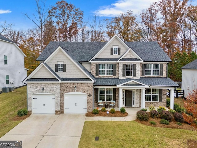 craftsman-style home featuring cooling unit, a porch, a garage, and a front lawn