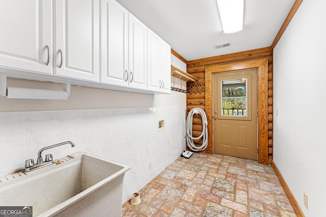 laundry area with sink, cabinets, tile walls, and washer hookup