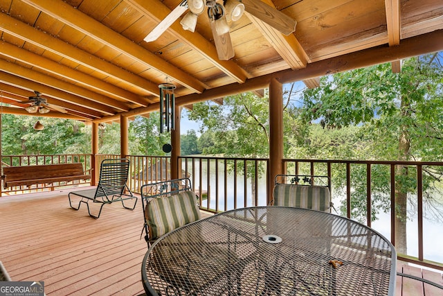 wooden deck with ceiling fan and a water view