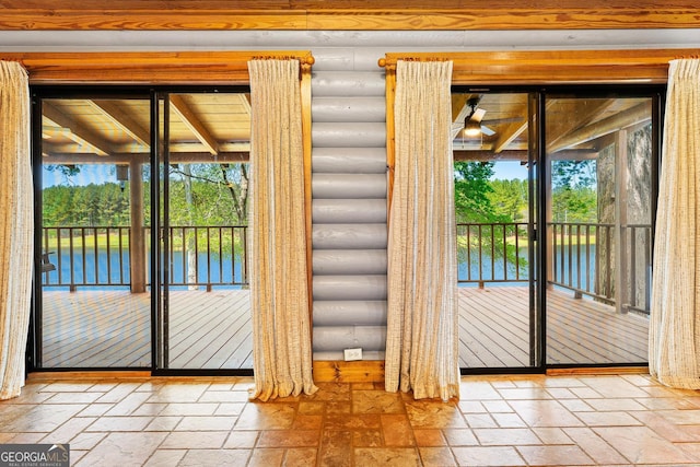 entryway with rustic walls, stone tile floors, and a water view