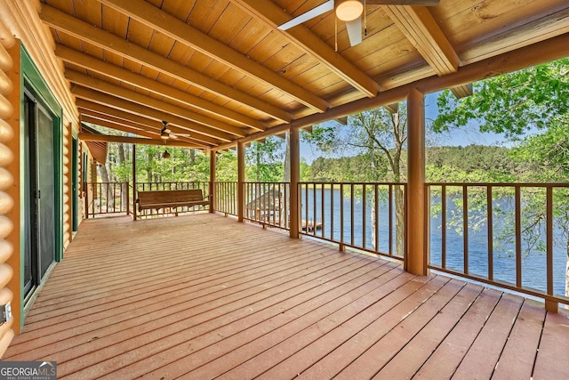 deck with a water view and ceiling fan