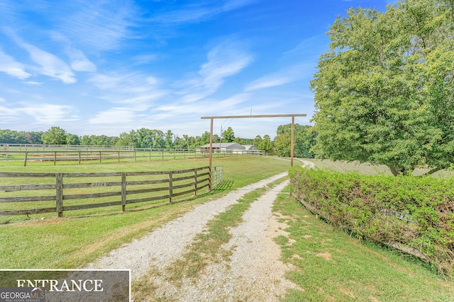 view of gate with a rural view and a yard